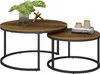 Two nesting coffee tables with wooden tops and black metal bases, decorated with a plant and books. Anteprima dell’immagine prodotto