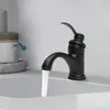 A black faucet is running water into a white sink, with a container of toiletries in the background. Podgląd zdjęcia produktu