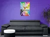 A poster of Pokemon characters is displayed on a purple wall above a gray sofa. A white and black cylindrical table is in the foreground. Produktbild-Vorschau