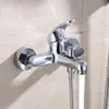A chrome-plated bathroom faucet with a shower hose attached, mounted on a tiled wall. Water is flowing from the faucet. Podgląd zdjęcia produktu