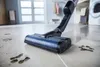 A close-up shot of a cordless vacuum cleaner head cleaning a dirty floor. Náhľad obrázku produktu