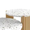 A close-up view of two round tables with a terrazzo-like pattern on top and wooden legs. Voir les images du produit