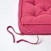 A close-up of a pink cushion with ties. Náhled obrázku produktu