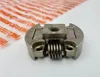 A close-up of a metal clutch part with springs, placed on a white surface. In the background, there is a blurred orange and white striped pattern. Produktbild-Vorschau