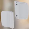Two white door handles are shown against a blurred background. Podgląd zdjęcia produktu