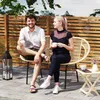 A couple sitting on a patio, enjoying drinks on a sunny day. Anteprima dell’immagine prodotto