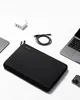 A black laptop sleeve is shown with a laptop, charger, and cable arranged around it. Produktbild-Vorschau