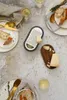 A top-down view of a table setting with bread, cheese, and a grater. Produktbild-Vorschau