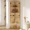 A tall, narrow glass display cabinet with two doors, filled with decorative items and bottles, placed in a well-lit room. Produktbild-Vorschau