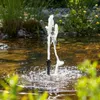 A small fountain spraying water in a pond surrounded by plants and rocks. Produktbild-Vorschau