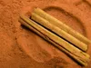 Close-up of cinnamon sticks on a bed of ground cinnamon. Produktbild-Vorschau