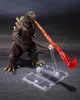A Godzilla action figure is shown in a dynamic pose, appearing to breathe atomic fire. It is displayed on a dark, textured surface with a clear plastic stand and base. Náhled obrázku produktu