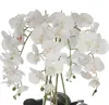 A close-up view of a white artificial orchid bouquet with green stems and leaves, set against a white background. Voir les images du produit