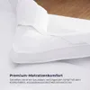 Weiße Matratzenauflage, die eine Matratze teilweise bedeckt, zeigt ihre Passform und Textur Náhled obrázku produktu