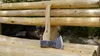 An axe rests on a wooden bench in an outdoor setting. Anteprima dell’immagine prodotto