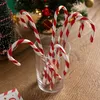Candy canes in a glass with a Christmas tree in the background. Anteprima dell’immagine prodotto