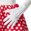 A close-up of a person's hand wearing a white glove, touching a red and white polka dot skirt. Produktbild-Vorschau