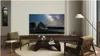A living room scene with a large TV displaying a starry night sky over a tent. Náhled obrázku produktu
