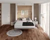 A bedroom scene with a bed, rug, and lamp. Produktbild-Vorschau