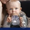 A baby drinking from a sippy cup. Produktbild-Vorschau
