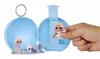 A hand holds a small doll in front of an open blue sphere-shaped toy case containing other small dolls and accessories. Produktbild-Vorschau