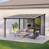 A patio shelter with outdoor furniture set up underneath, next to a house. Anteprima dell’immagine prodotto