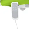 A close-up of an electric massage table's remote control and a portion of the green mattress. Náhled obrázku produktu