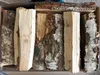 A top-down view of several pieces of firewood neatly arranged in a cardboard box. Produktbild-Vorschau