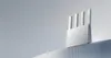 A modern white router with four antennas is displayed on a textured surface against a light gray background. Náhľad obrázku produktu