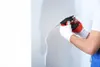 A person is applying plaster to a wall with a trowel. Anteprima dell’immagine prodotto