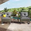 Two rattan chairs and a small table are set up on a wooden deck next to a swimming pool, with a lush green hillside in the background. Podgląd zdjęcia produktu