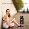 A woman is sitting on the ground next to a portable Bluetooth speaker with a smartphone on top. Podgląd zdjęcia produktu