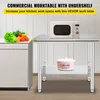 A commercial work table with an undershelf, shown in a kitchen setting with a microwave on top and a pot on the shelf. Vegetables are on an adjacent counter. Podgląd zdjęcia produktu