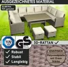 A polyrattan garden lounge set with a table and stools on a grassy lawn. Produktbild-Vorschau