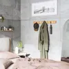 A bedroom scene with a coat rack mounted on a tiled wall. Produktbild-Vorschau