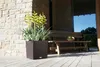 A planter with plants on a wooden deck next to a wooden bench. Náhled obrázku produktu
