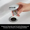 A hand is shown inserting a drain stopper with a hair catcher into a sink drain. Produktbild-Vorschau