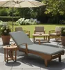 A patio scene with outdoor furniture, including a chaise lounge, chairs, and a table, set in a garden. Produktbild-Vorschau
