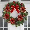A Christmas wreath decorated with red poinsettias, pine cones, and gold accents, hanging on a white door. Produktbild-Vorschau
