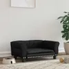 A black dog bed is shown in a room with a white wall and a plant in the background. Náhľad obrázku produktu