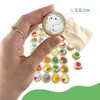 A hand holding a wooden token with a cat illustration, surrounded by other tokens and dice. Anteprima dell’immagine prodotto