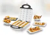 Der Unold Waffelautomat Zaubernuss steht auf einer weißen Fläche, umgeben von Tellern mit Gebäck, ge Produktbild-Vorschau