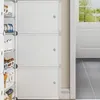 A modular shoe cabinet with white doors, placed next to a doorway with a view of trees outside. Náhľad obrázku produktu