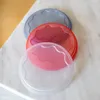 Three round, wavy-edged lids are stacked on a marble surface. Anteprima dell’immagine prodotto