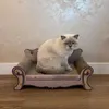 A cat is sitting on a stylish, antique-style cat sofa that also functions as a scratching post. Voir les images du produit