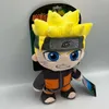A plush toy of the anime character Naruto Uzumaki is displayed against a light gray and white background, with its packaging visible behind it. Anteprima dell’immagine prodotto