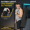 A man is carrying a rolled-up gym mat over his shoulder in a gym setting. Produktbild-Vorschau