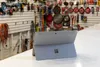 A Microsoft Surface Go 2 tablet is displayed on a white surface in front of a wall of tools. Produktbild-Vorschau