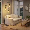 A living room scene with a floor lamp, sofa, and coffee table. Produktbild-Vorschau