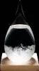 A storm glass barometer with a wooden base against a black background. Voir les images du produit